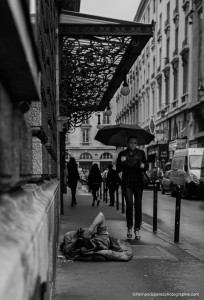 Un homme se protégeant du froid et de la pluie. Des yeux qui l'observent. Et une élégante parisienne, bien parfummée sur ses talons, qui passe comme si ce n'était qu'un lointain souvenir.