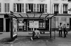 Gay Pride, la grande célébration homosexuelle. Un homme dort sous un abribus, une couverture masquant son visage pour que personne ne puisse le voir. A côté, un couple est sorti du cortège pour discuter, et à la fenêtre, un homme prend des photos sur son Ipad. Personne ne s'intéresse à cet homme dans l'abribus. Aujourd'hui, ce qui est important, c'est de ne pas rater le bus.